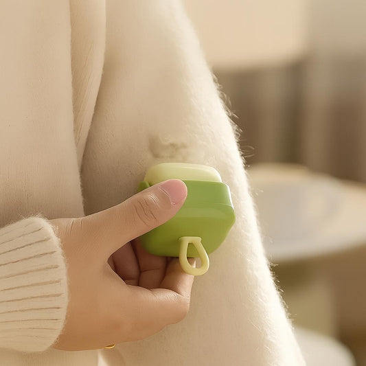 image showing just the hand in a cream sweater holding the green cleaning device