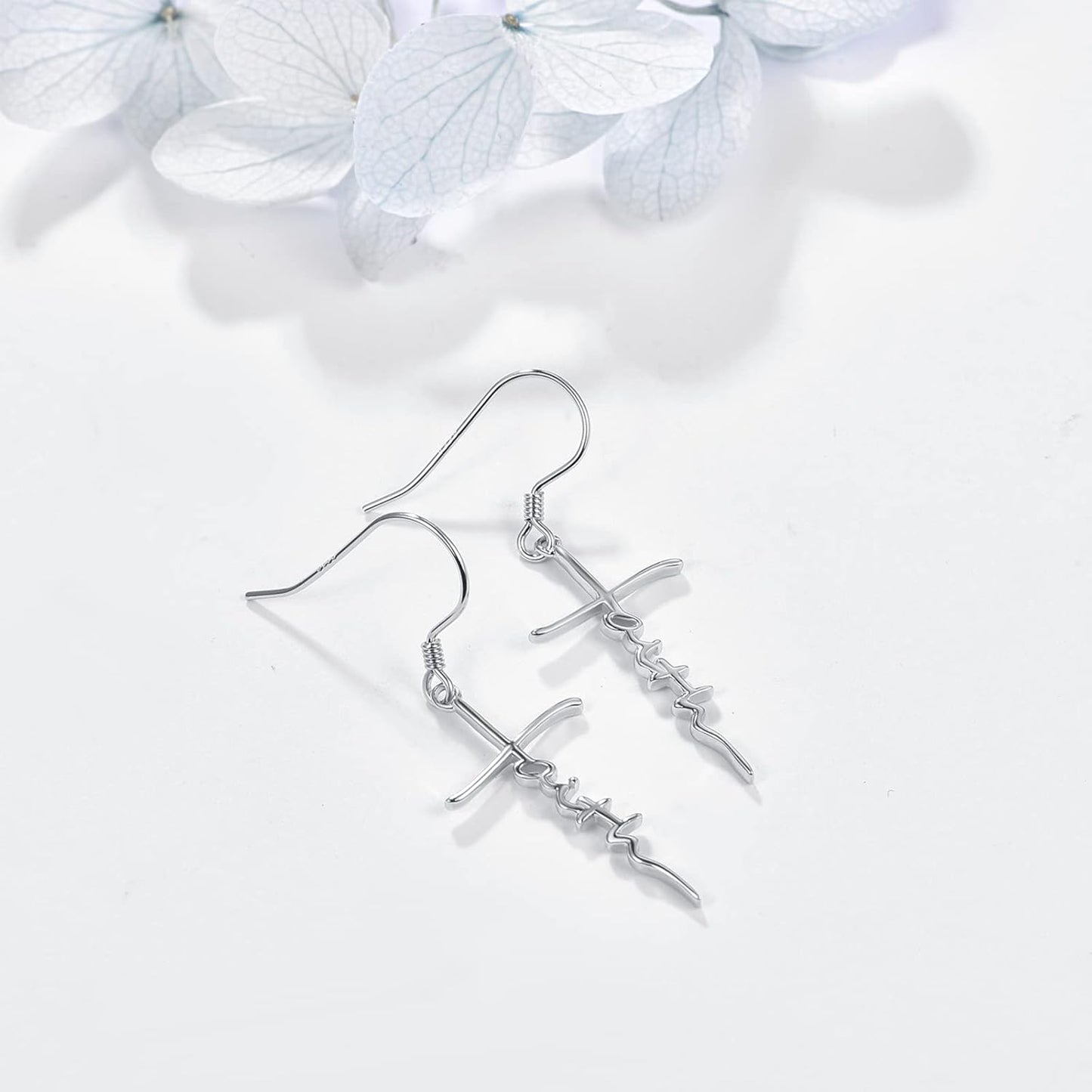 Silver earrings on a white background with light hydrangea flowers