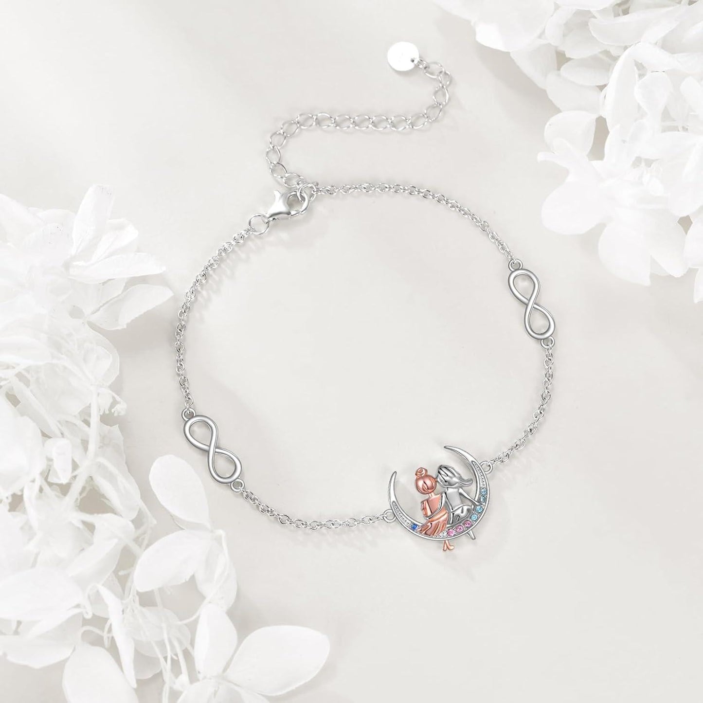 Silver bracelet with heart and infinity symbol on a white background