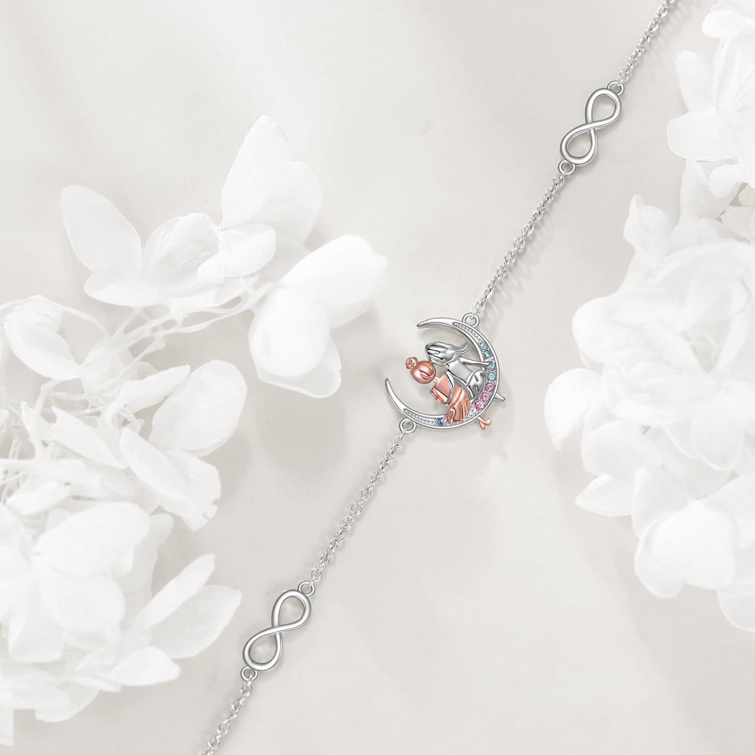 Silver necklace with a heart and infinity symbol pendant on a white floral background