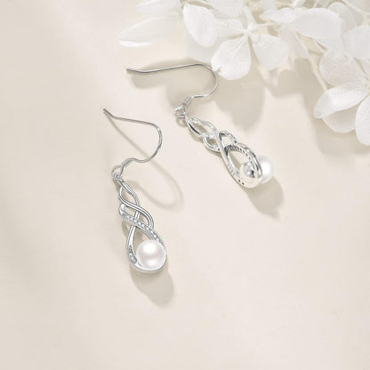 Silver earrings with a pearl on a light background