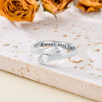 Silver ring with 'Always with You' engraving on a textured surface with dried roses.