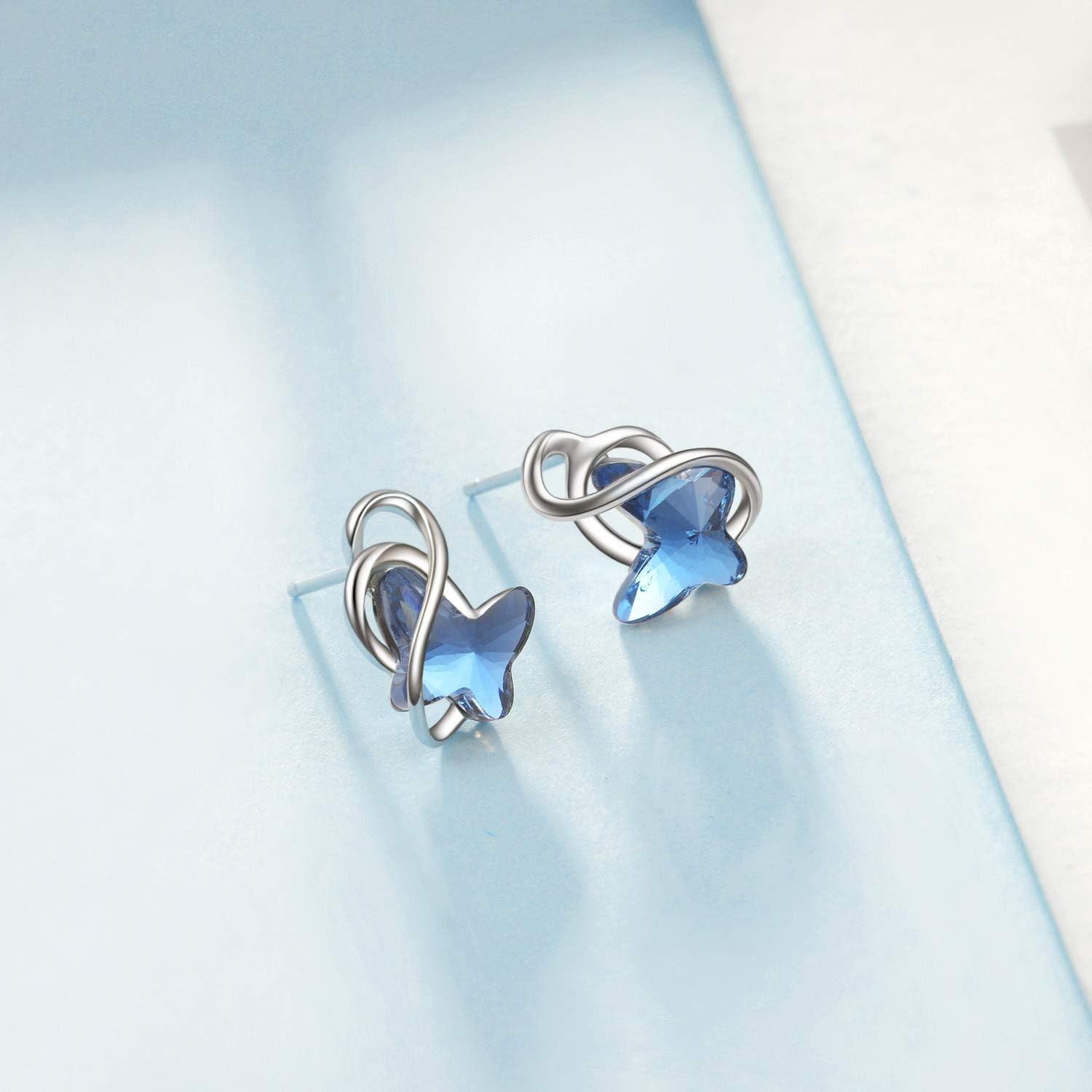 Pair of silver earrings with blue gemstones on a light blue background