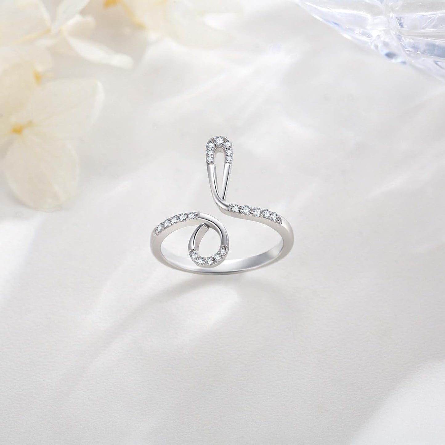 Silver ring with small diamonds on a white fabric background