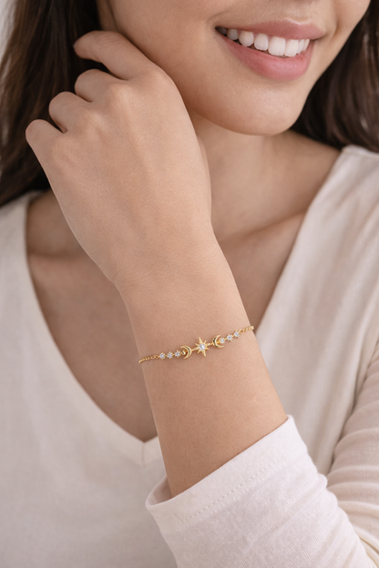 Woman wearing a delicate bracelet with small beads and stars on a plain background