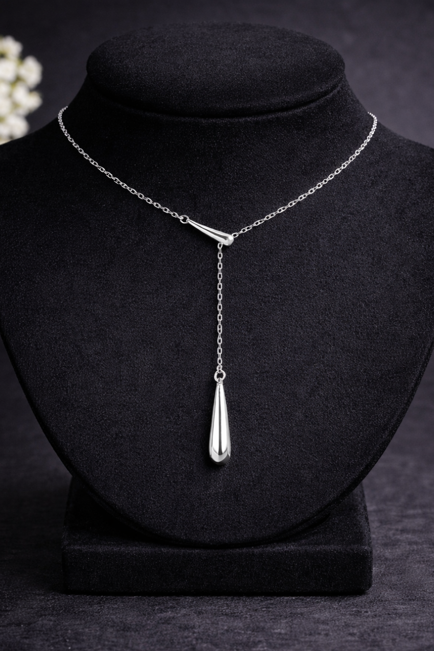 Silver geometric water droplet Y-necklace with French fringe on a black mannequin bust.