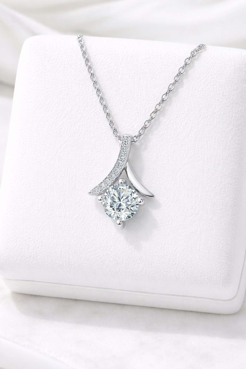 Silver necklace with a diamond pendant on a white box