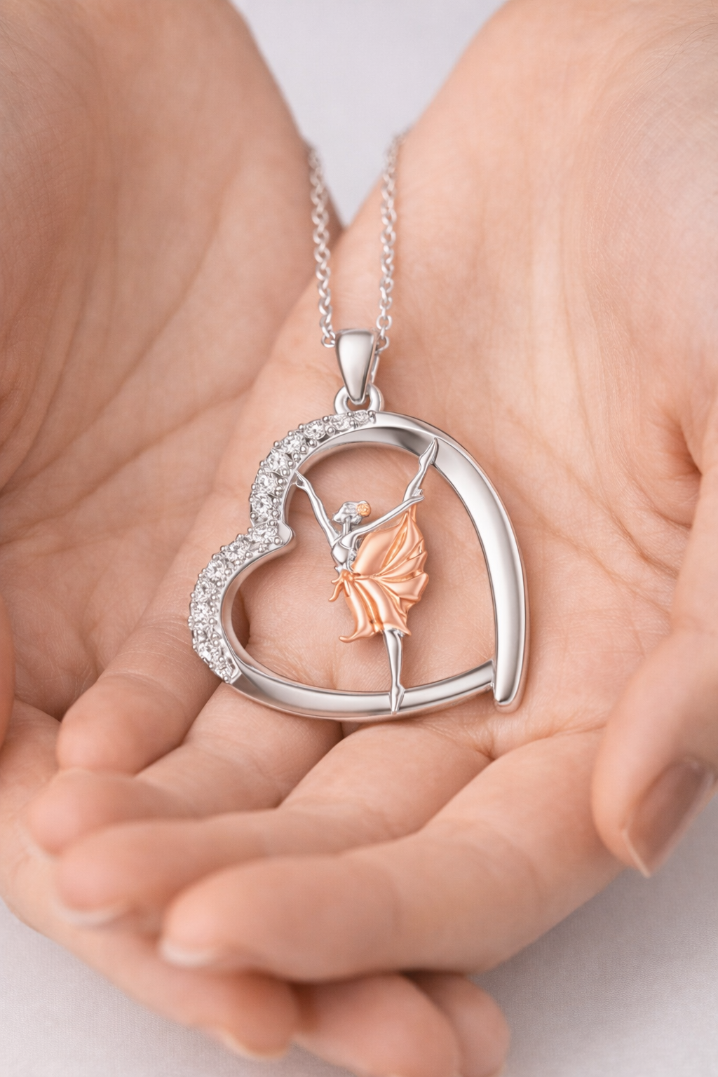 Heart-shaped pendant with a fairy design held in hands
