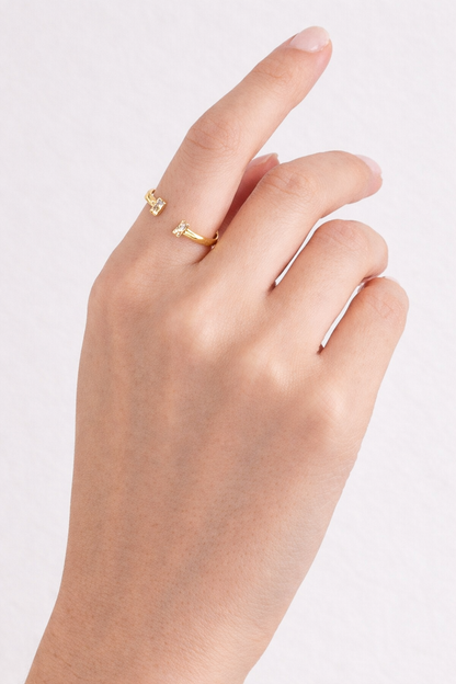 Hand wearing a gold ring on a light background