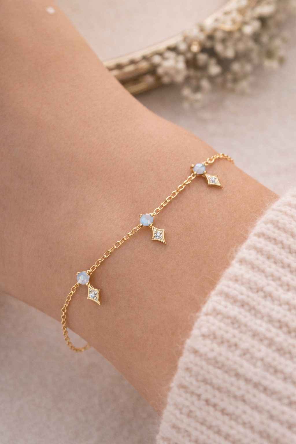 Gold bracelet with gemstones on a wrist, with a soft background