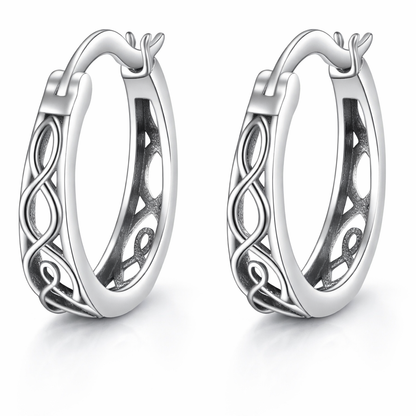 Pair of silver hoop earrings with intricate designs on a white background