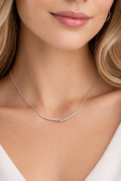 Silver necklace on a model with a plain background