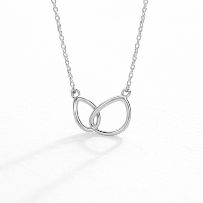 Silver necklace with a double interlocking ring pendant on a white background