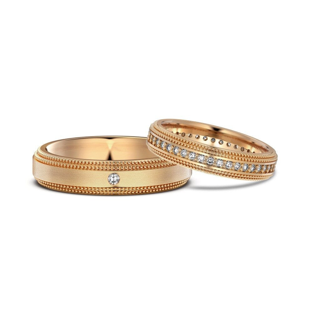 Two gold wedding bands with diamond accents on a white background