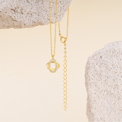 Gold necklace with a unique pendant on a textured beige surface