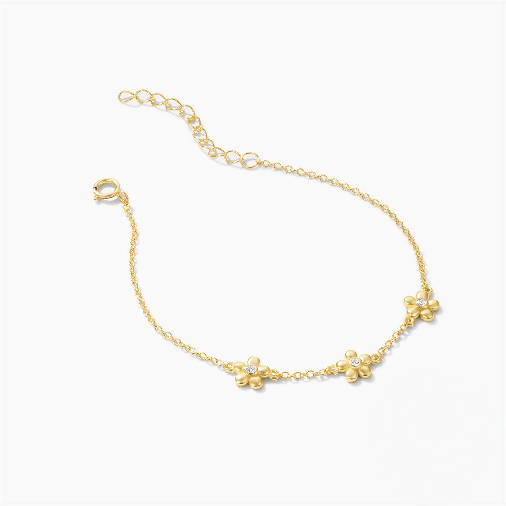 Gold bracelet with floral designs on a white background