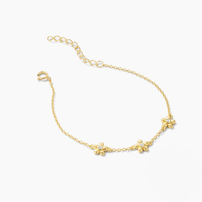 Gold bracelet with floral designs on a white background