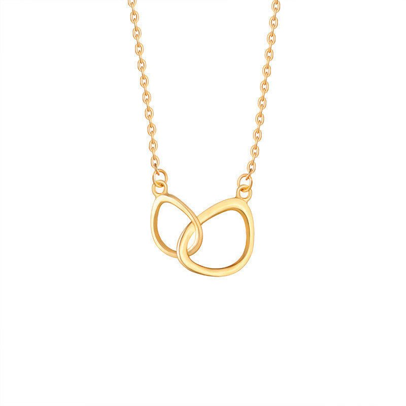 Gold necklace with a double interlocking ring pendant on a white background