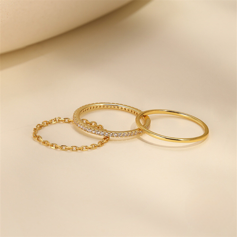 Three gold rings on a beige background