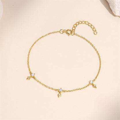 Gold bracelet with star-shaped charms on a beige background