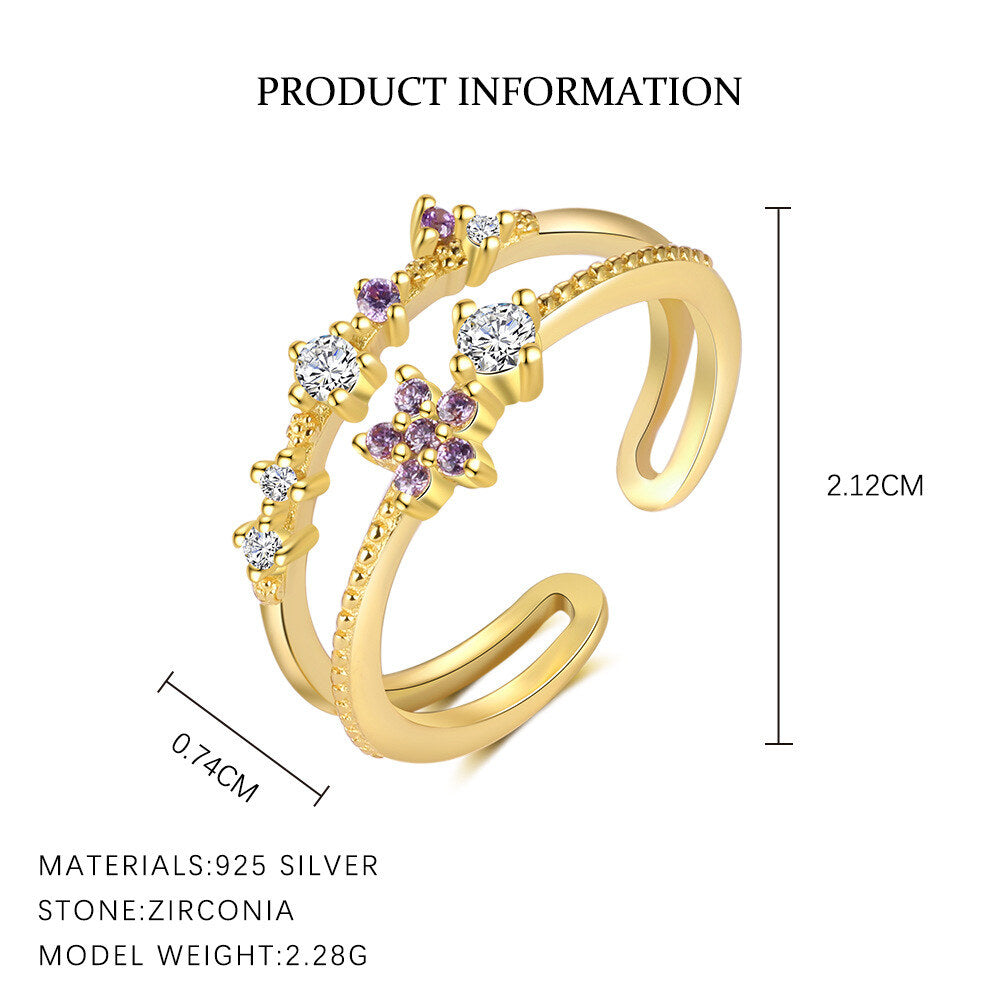 Gold ring with zirconia stones and measurements on a white background
