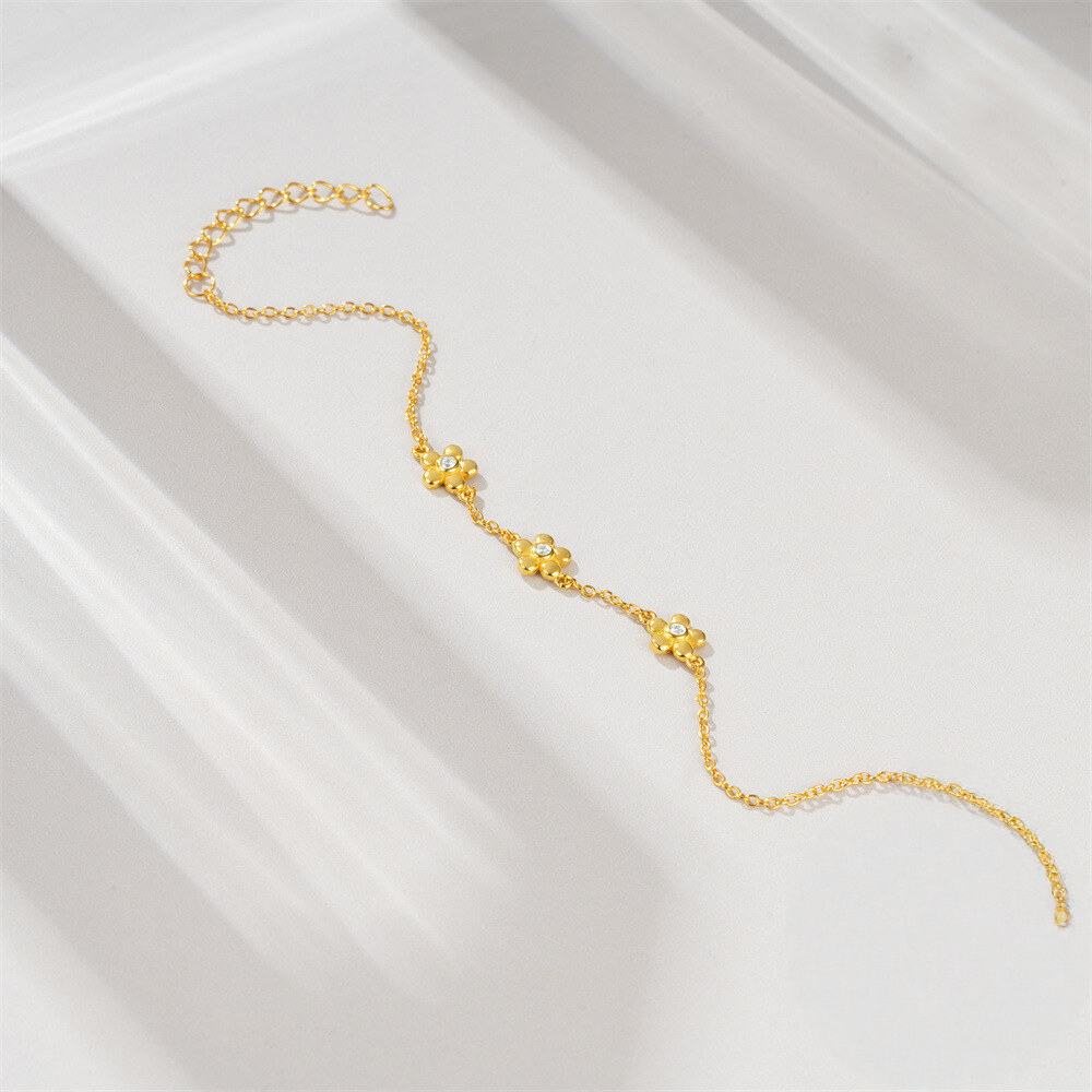 Gold bracelet on a white satin surface