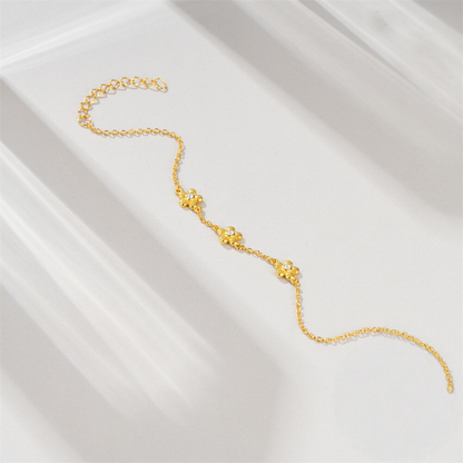 Gold bracelet on a white satin surface