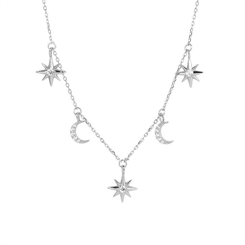 Silver necklace with star and moon pendants on a white background