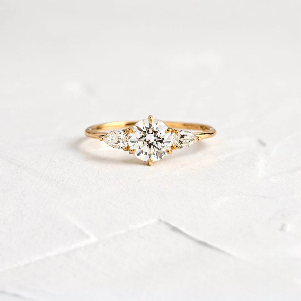 Gold ring with a diamond on a light gray background