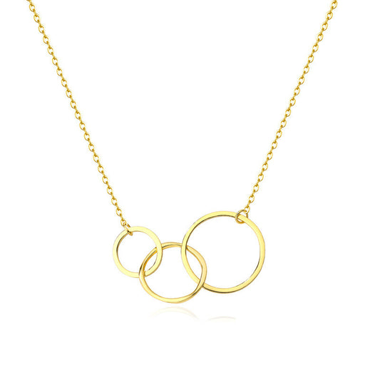 Gold necklace with three interlocking rings on a white background