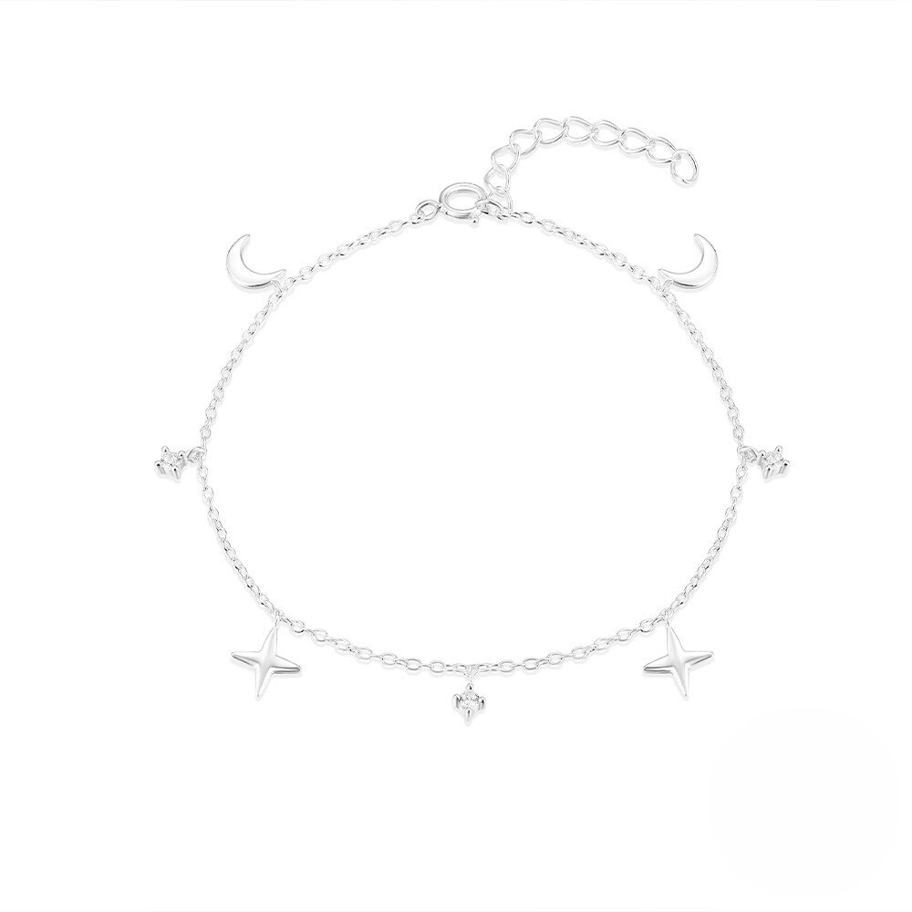 Silver bracelet with star and moon charms on a white background
