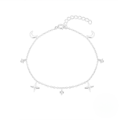 Silver bracelet with star and moon charms on a white background