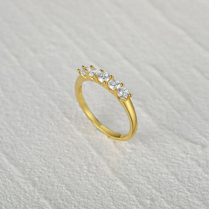 Gold ring with diamonds on a light gray textured background