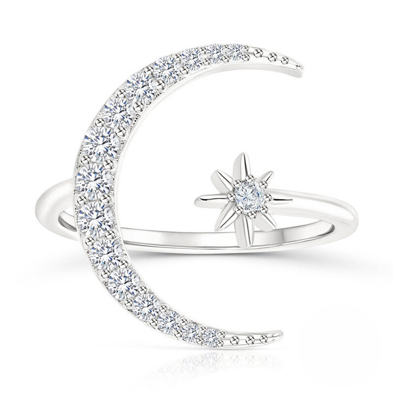 Silver ring with moon and star design on a white background