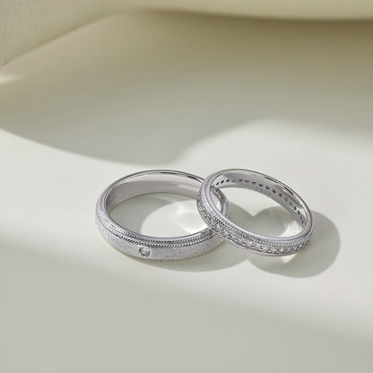 Two silver rings with intricate designs on a light beige background
