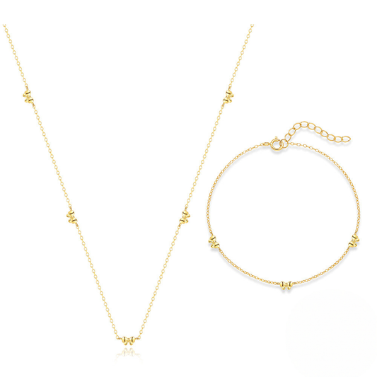 Gold necklace and bracelet set on a white background