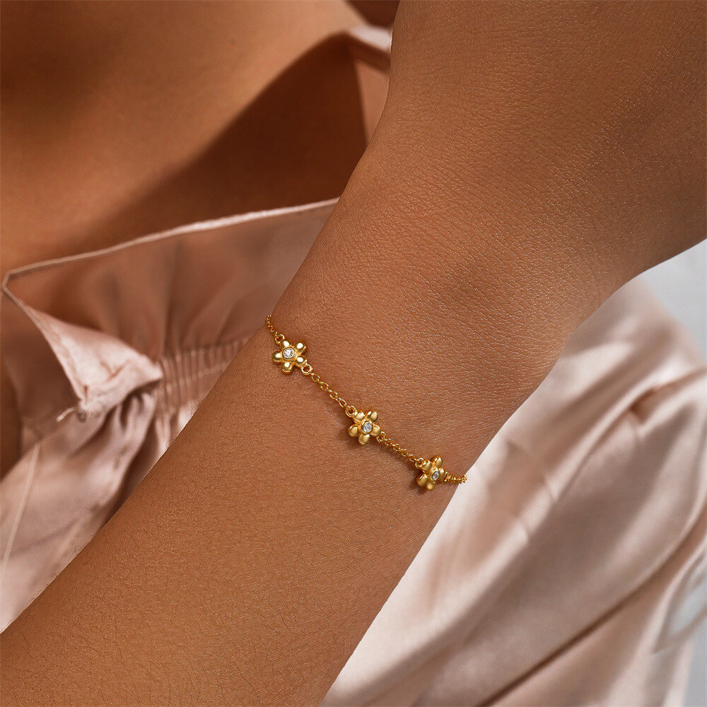 Gold anklet on a person's ankle with a soft background