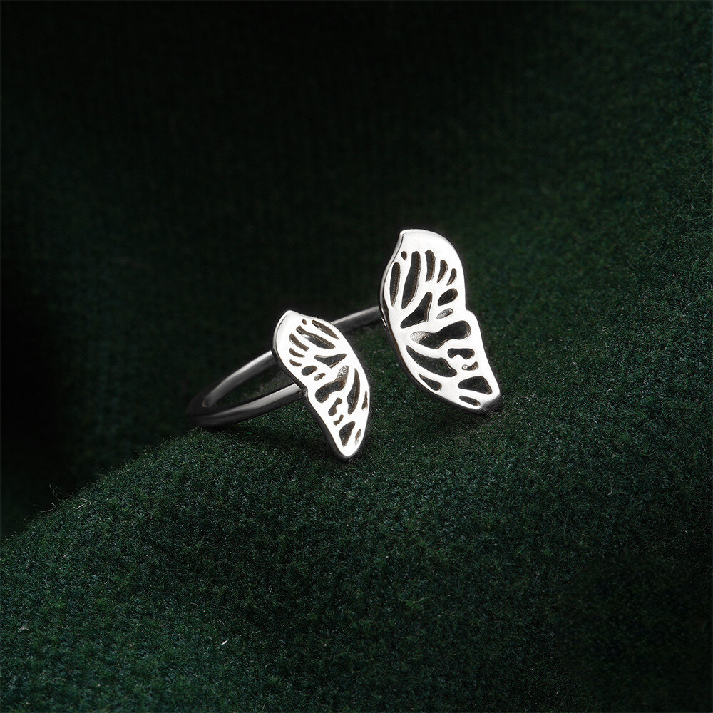 Silver leaf-shaped earrings on a dark green fabric background