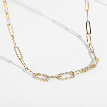 Gold chain necklace with diamond accents on a white background