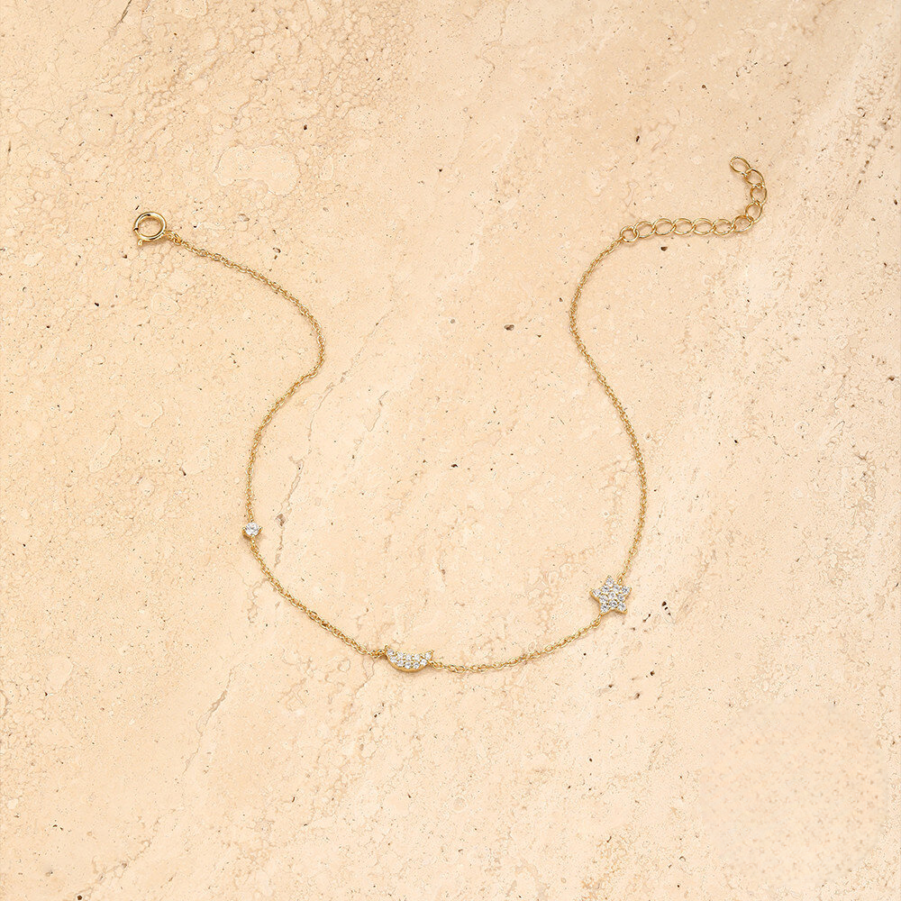 Gold bracelet with small diamonds on a beige textured background