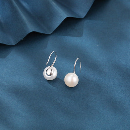 Pearl earrings on a blue fabric background