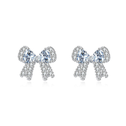 Bow-shaped earrings with clear gemstones on a white background