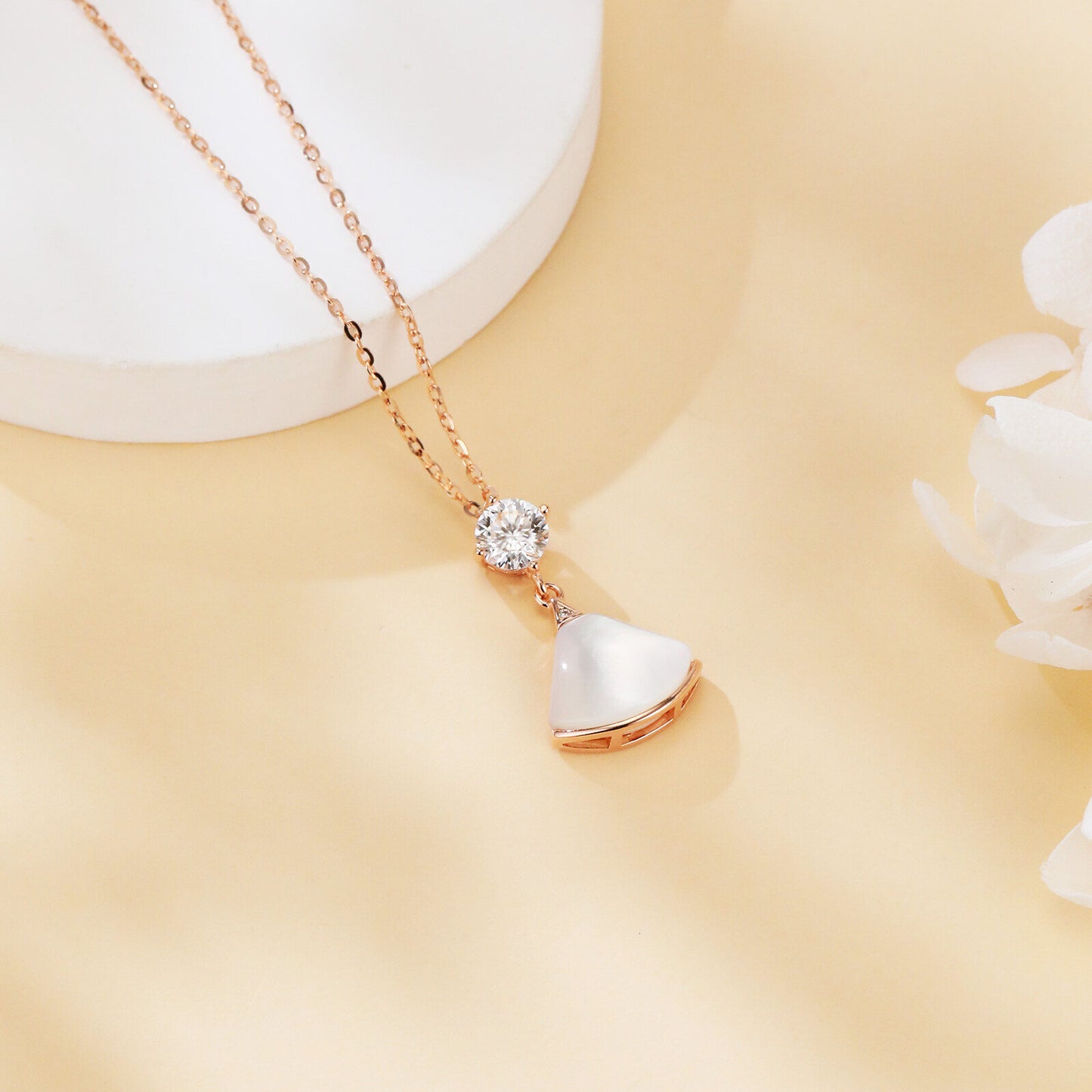 Rose gold necklace with a heart-shaped pendant on a beige background