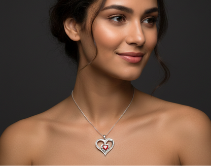 Woman wearing a silver necklace with a heart-shaped pendant on a dark background 

